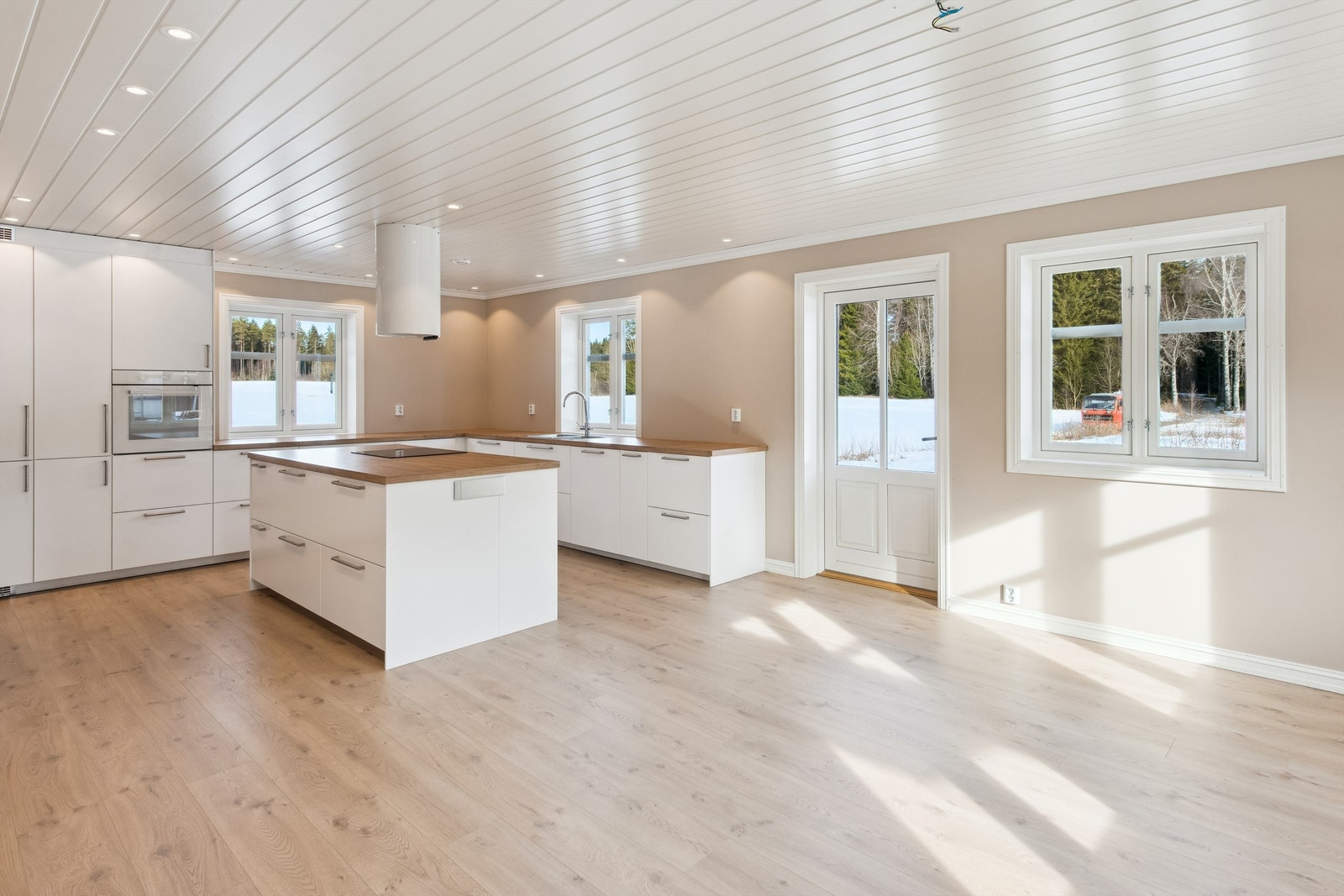 Innholdsrik kjøkkeninnredning med stor kjøkkenøy fra Ikea. Integrerte hvitevarer som kjøl/frys, komfyr, oppvaskmaskin, platetopp og ventilator Galleribilde