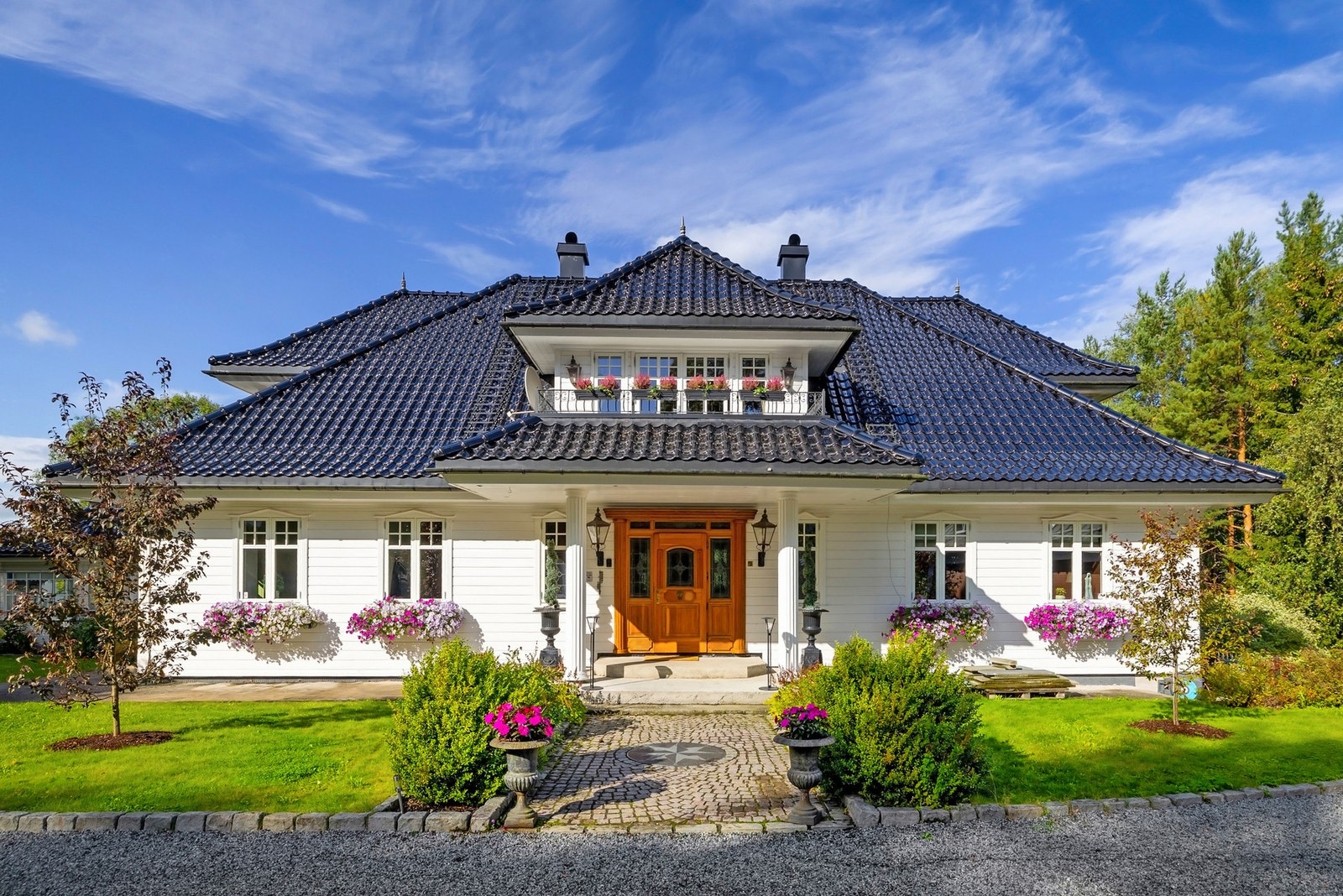 Nydelig steinlagt adkomst med frodige blomsterkrukker. Galleribilde