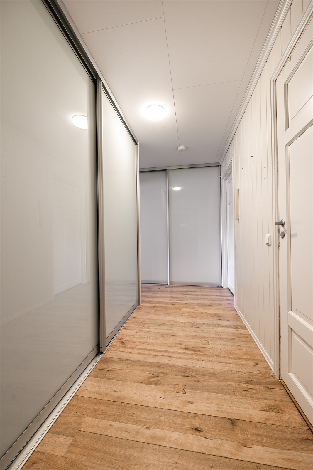 Soveromsgangen er praktisk innredet med skyvedørsgarderober. Her er det det også adkomst til loft fra loftstige. Galleribilde