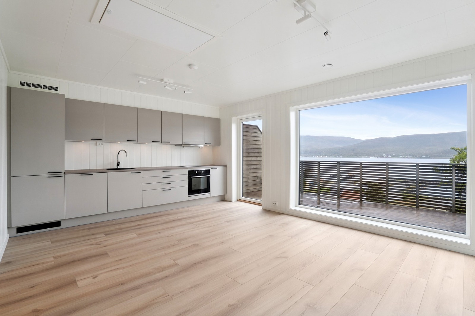 Stue med flott kjøkken med integrerte hvitevarer. Galleribilde