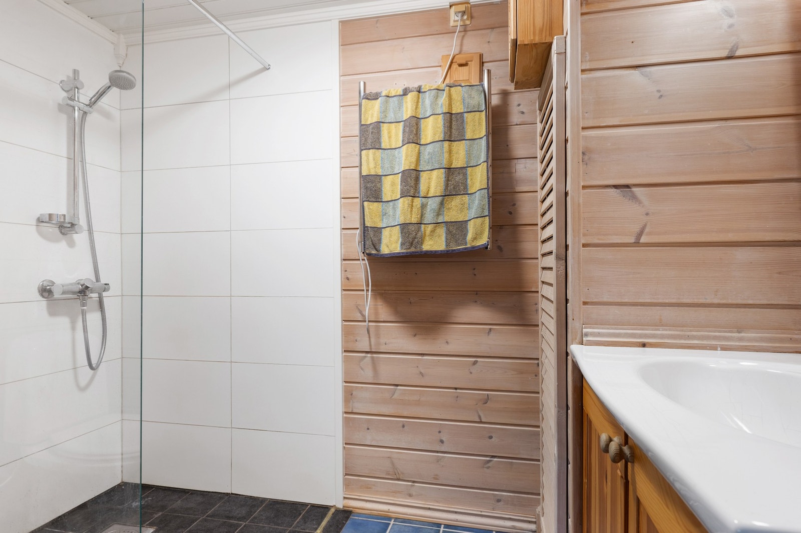 Bad fra byggeåret i underetasjen. Noe oppgradering i senere tid. Rommet har gulvstående wc, servantskap og dusj. Galleribilde