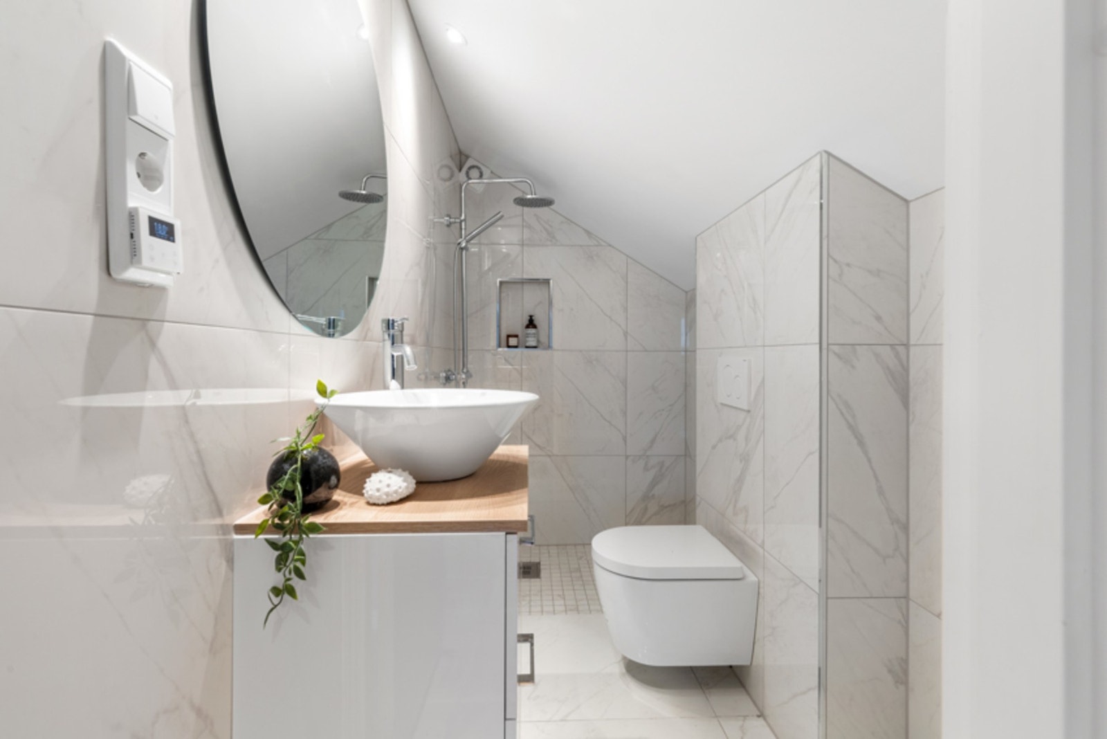 Som resten av leiligheten, er badet fra 2022. Det er delikat, med lyse marmorfliser på gulv og vegger. Galleribilde