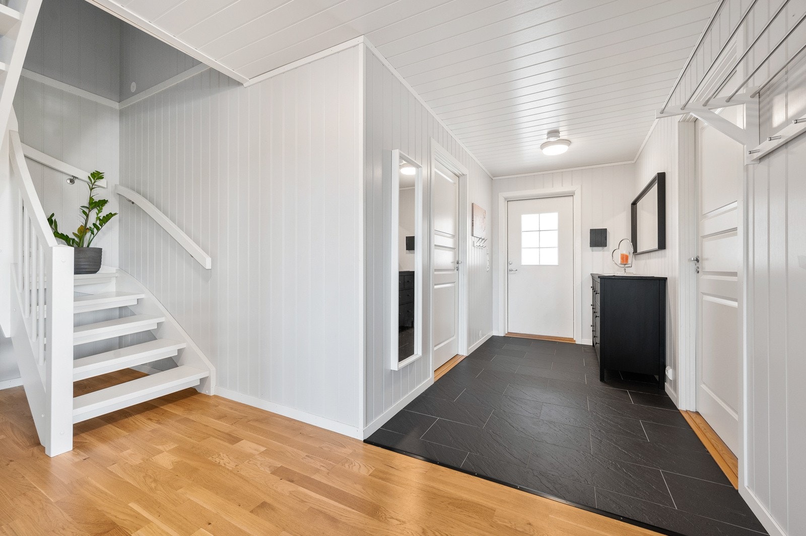 Innbydende entré med god plass til garderobe og praktisk klesoppheng på veggen. Gulvet er dekket med fliser som har varmekabler for ekstra komfort. Galleribilde