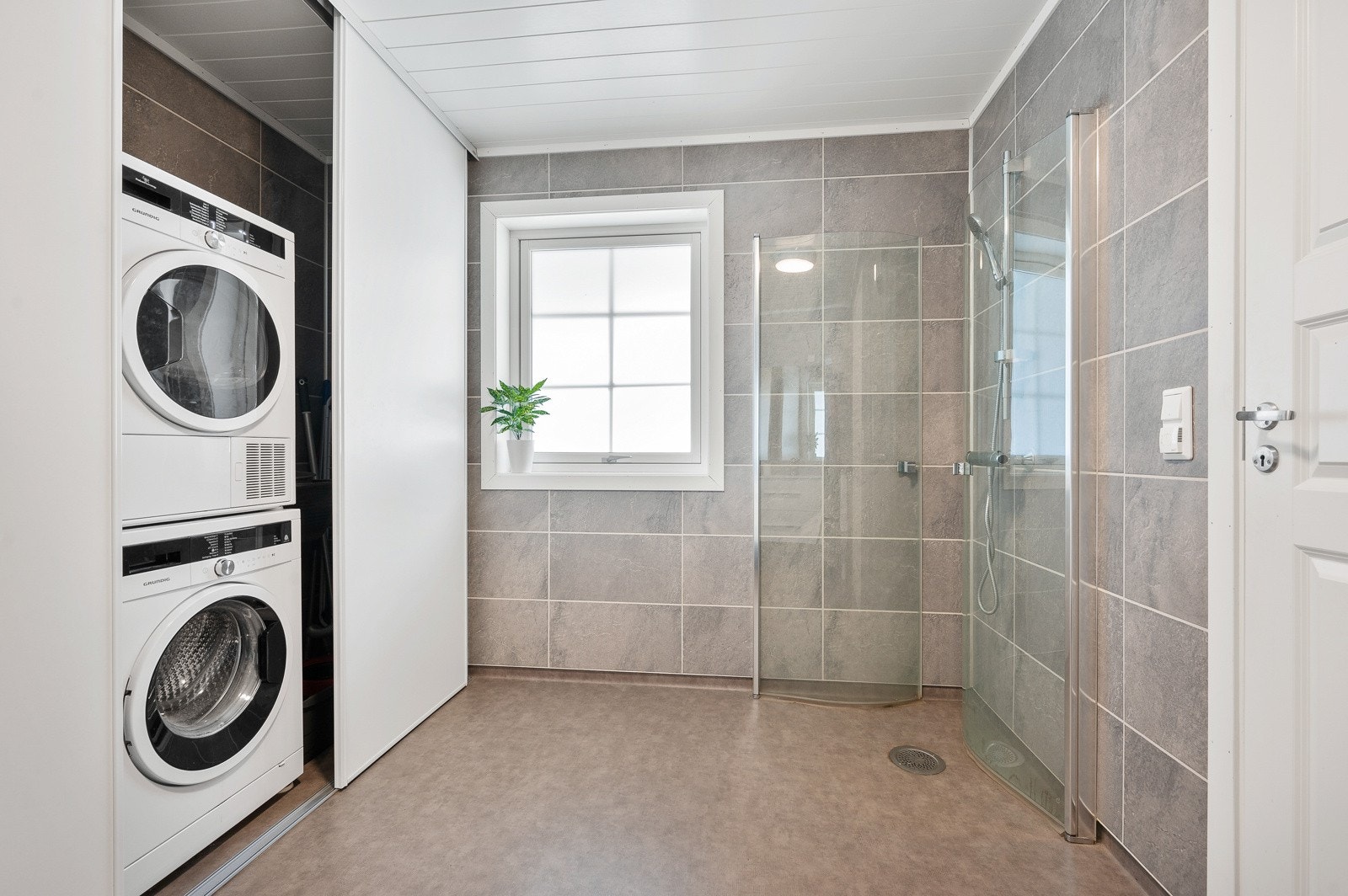 tillegg har badet en praktisk vaskeromsavdeling bak skyvedører, med tilkoblinger for både vaskemaskin og tørketrommel. Galleribilde