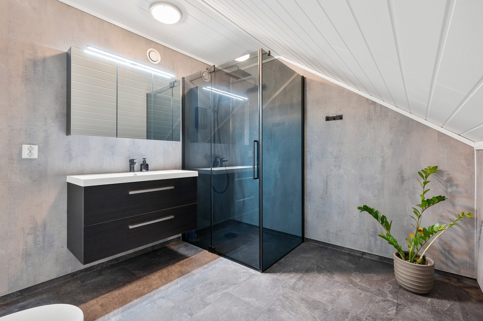 Delikat baderom med ekstra bred servant, hylleløsning med lys og stor dusj med waterfall. Klosett. Galleribilde