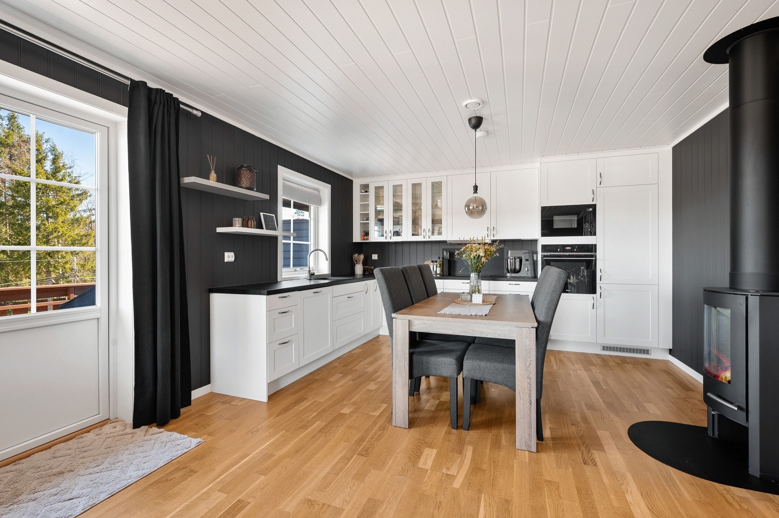 Stuen har nyere parkettgulv og en moderne peisovn, som gir både komfort og stil til rommet. Galleribilde