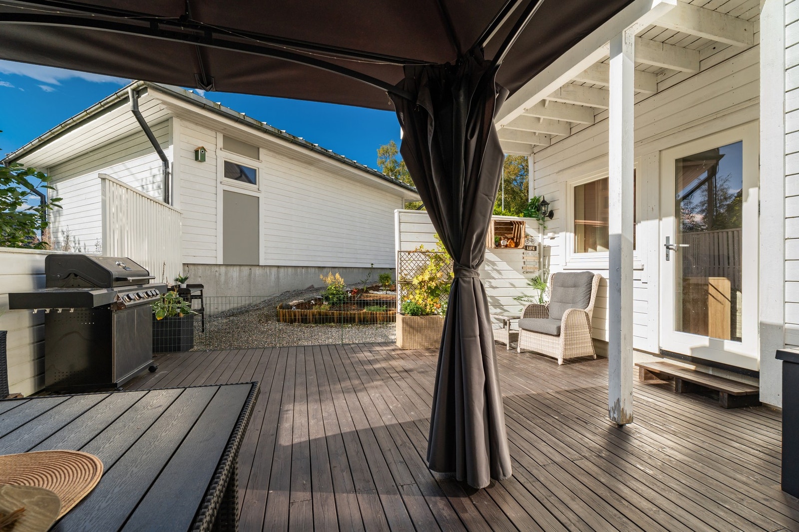 Fra terrassen er det utgang til resten av uteområdet samt til garasjen Galleribilde