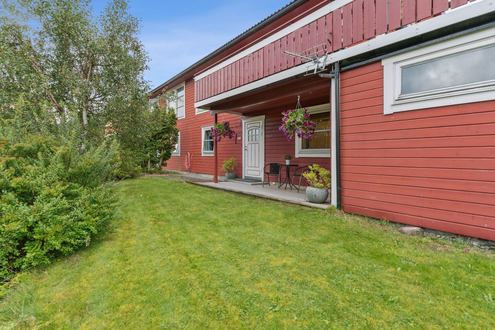 Opparbeida hage med plen og plantar. Takterrasse på garasje. Galleribilde