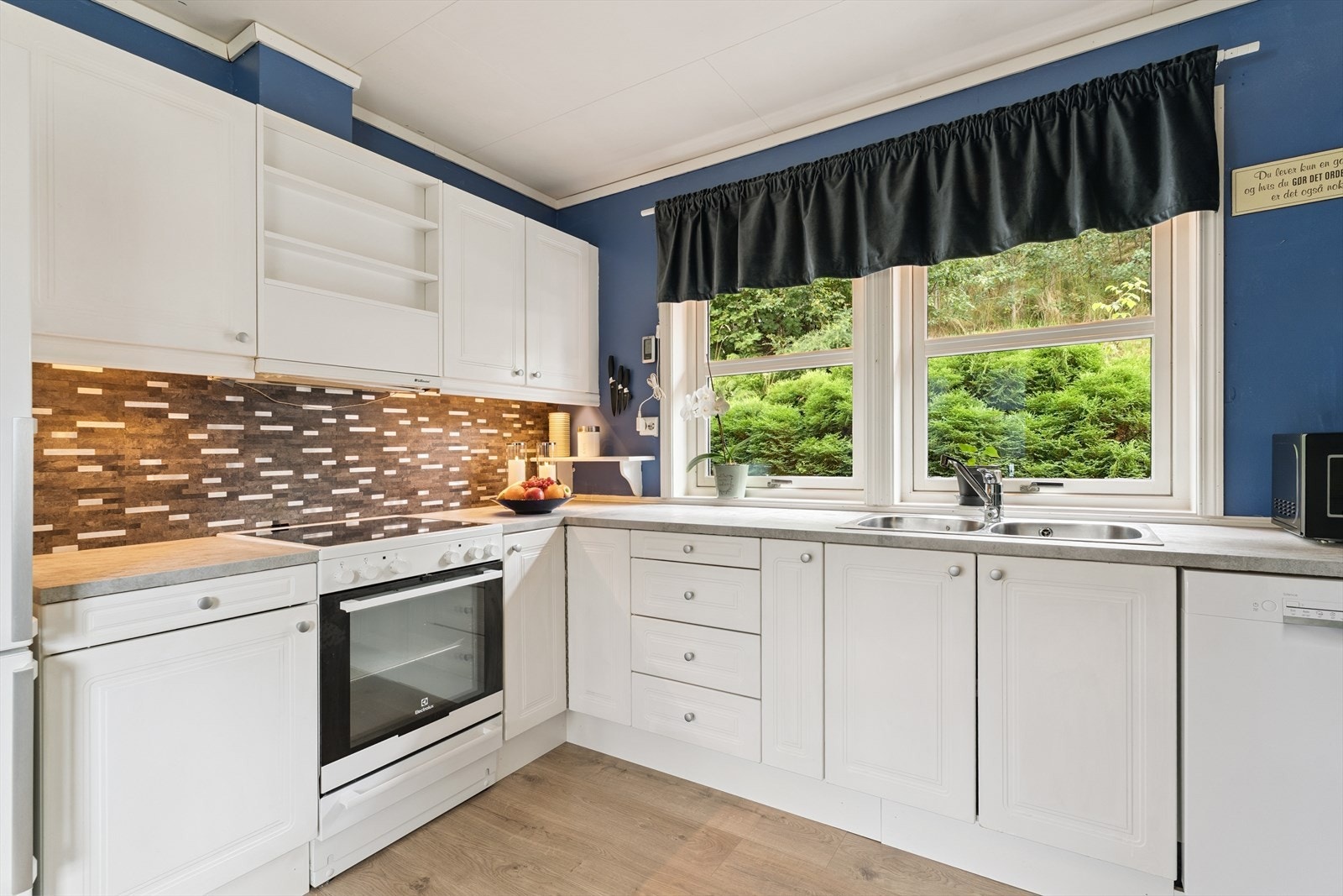 Kjøkkeninnreiinga har profilerte frontar og laminert, kvit benkeplate.
Frittståande kvitevarer - oppvaskemasking vil følgje i salet.
Du har også to kjøkkenvindauge som git deg utsyn til hage og godt med lys inn i rommet. Galleribilde