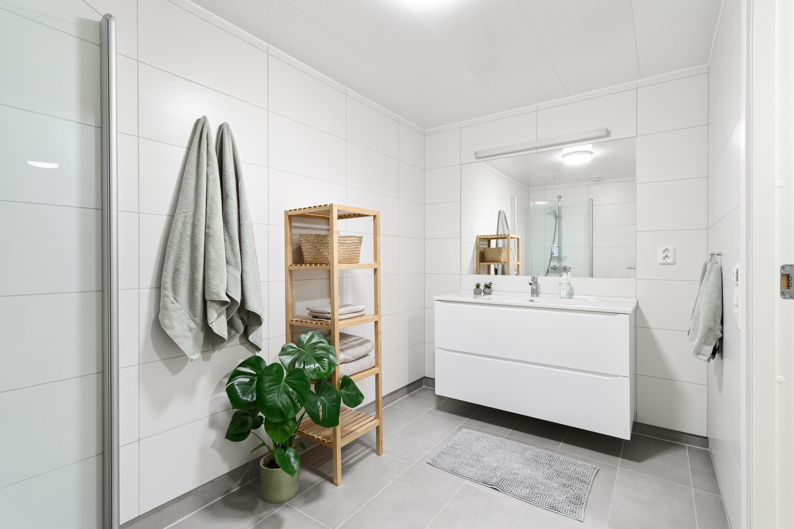 Baderommet er romslig med godt utnyttet plass. Her slipper man å bekymre seg for at vaskemaskin, tørketrommel og tørkestativ tar opp plass, da leiligheten har et eget separat vaskerom. Galleribilde