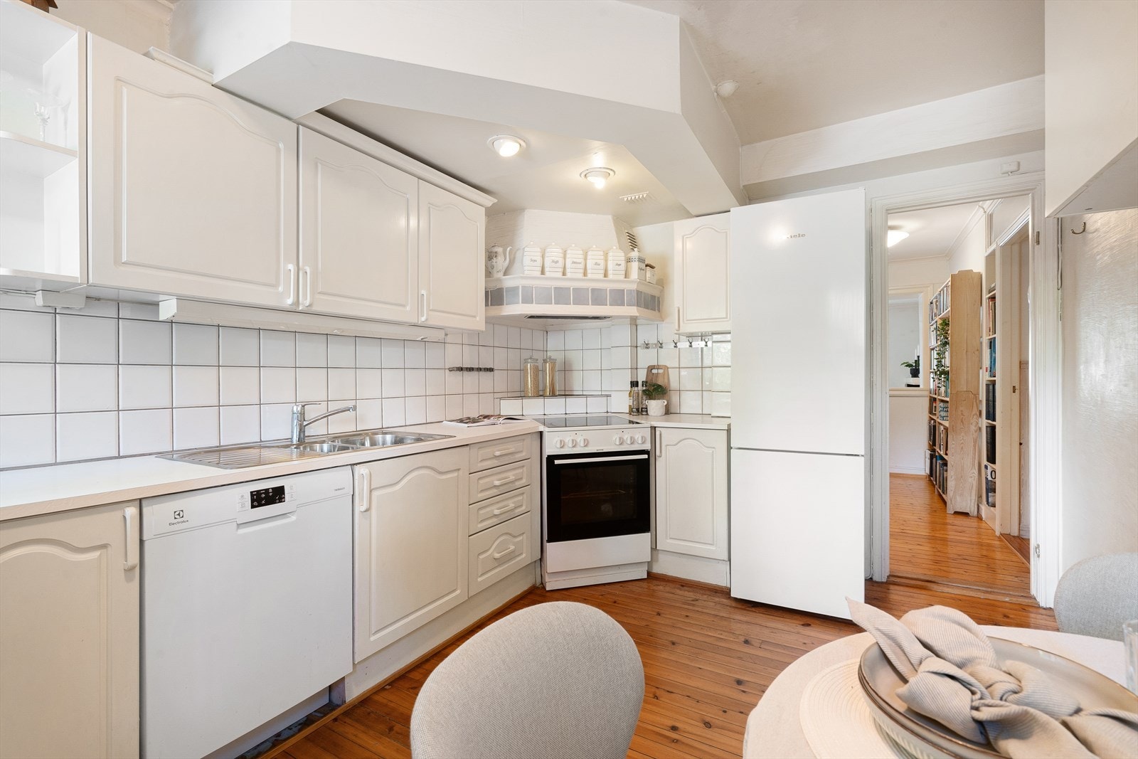 Tregulv, og flis på vegg over benkeplate og pusset overflate på vegger. Galleribilde