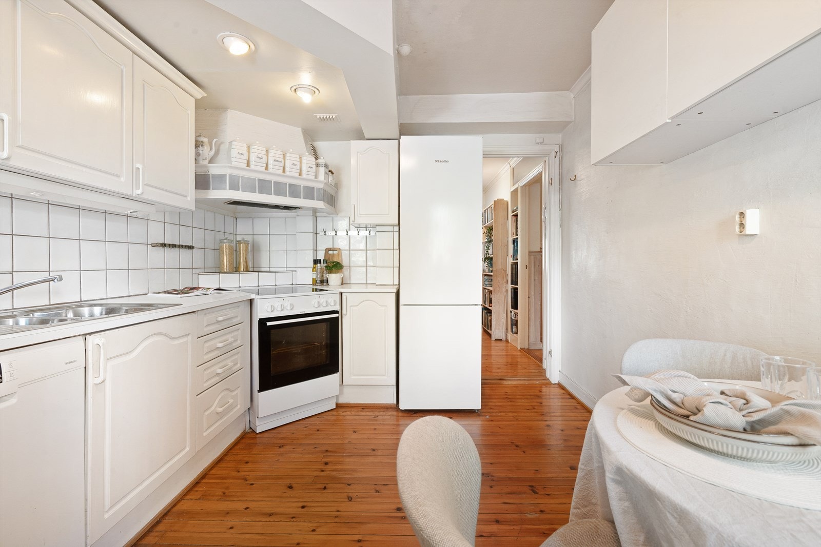 Kjøkkenet har frittstående kjøl/fryseskap, oppvaskmaskin, og komfyr med platetopp med kullfiltervifte over stekesonen. Galleribilde