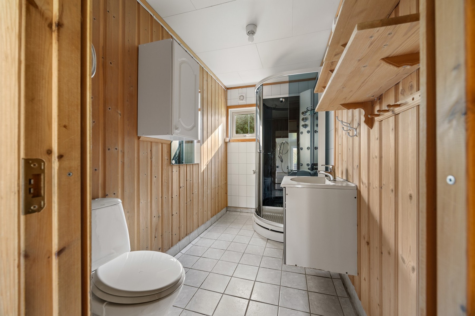 Bad/vaskerom - 4,5 kvm. Flislagt gulv med varme. Utstyrt med dusjkabinett, servantskap, toalett og opplegg for vaskemaskin Galleribilde