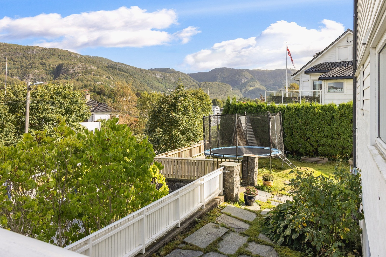 Hagen er solrik og skjermet med grønn plen, frukttrær og bærbusker som skaper en hyggelig ramme rundt huset. Galleribilde