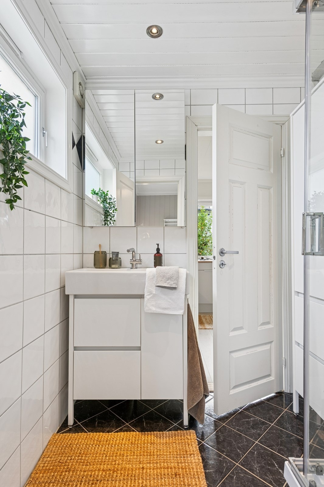 Badet er utstyrt med servant med underskap, speilskap og et dusjkabinett. Galleribilde