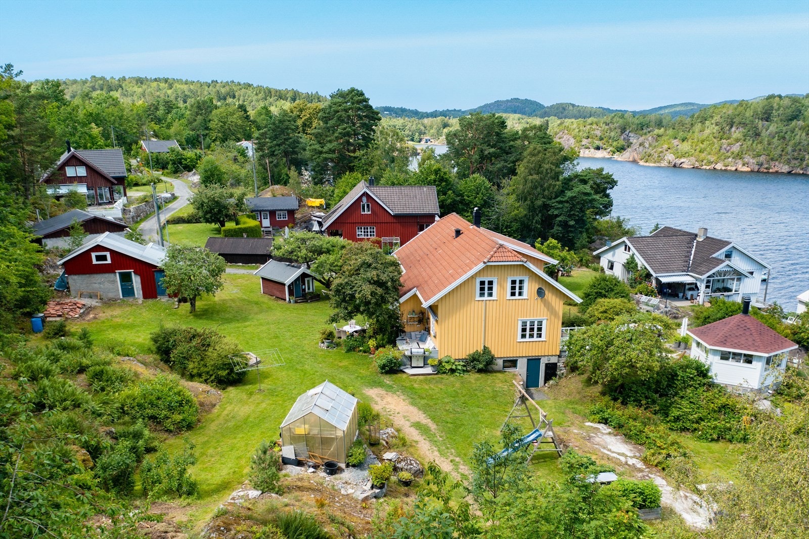 På tomten er det foruten boligen, en sjøbod, drivhus, 2 boder, garasje og lysthus Galleribilde