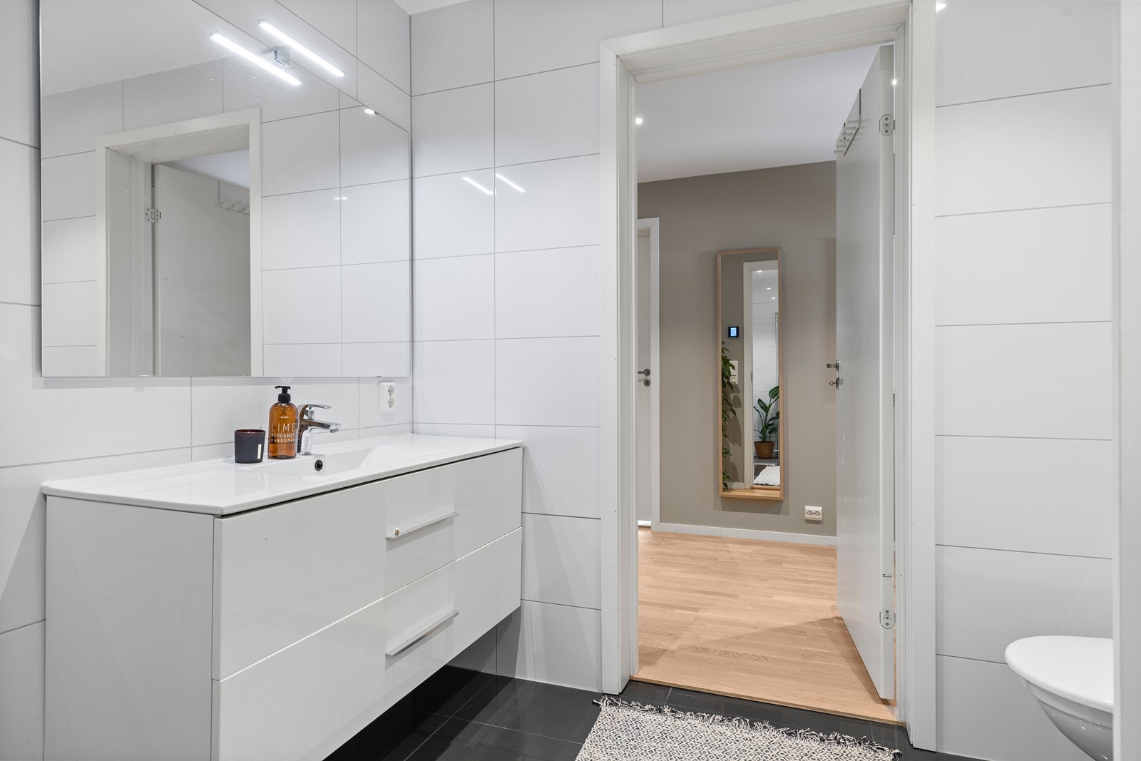 Badet i 1. etasje er moderne og stilrent, med vaskerom skjult bak skyvedører - en smart løsning som gir et ryddig og helhetlig uttrykk. Galleribilde