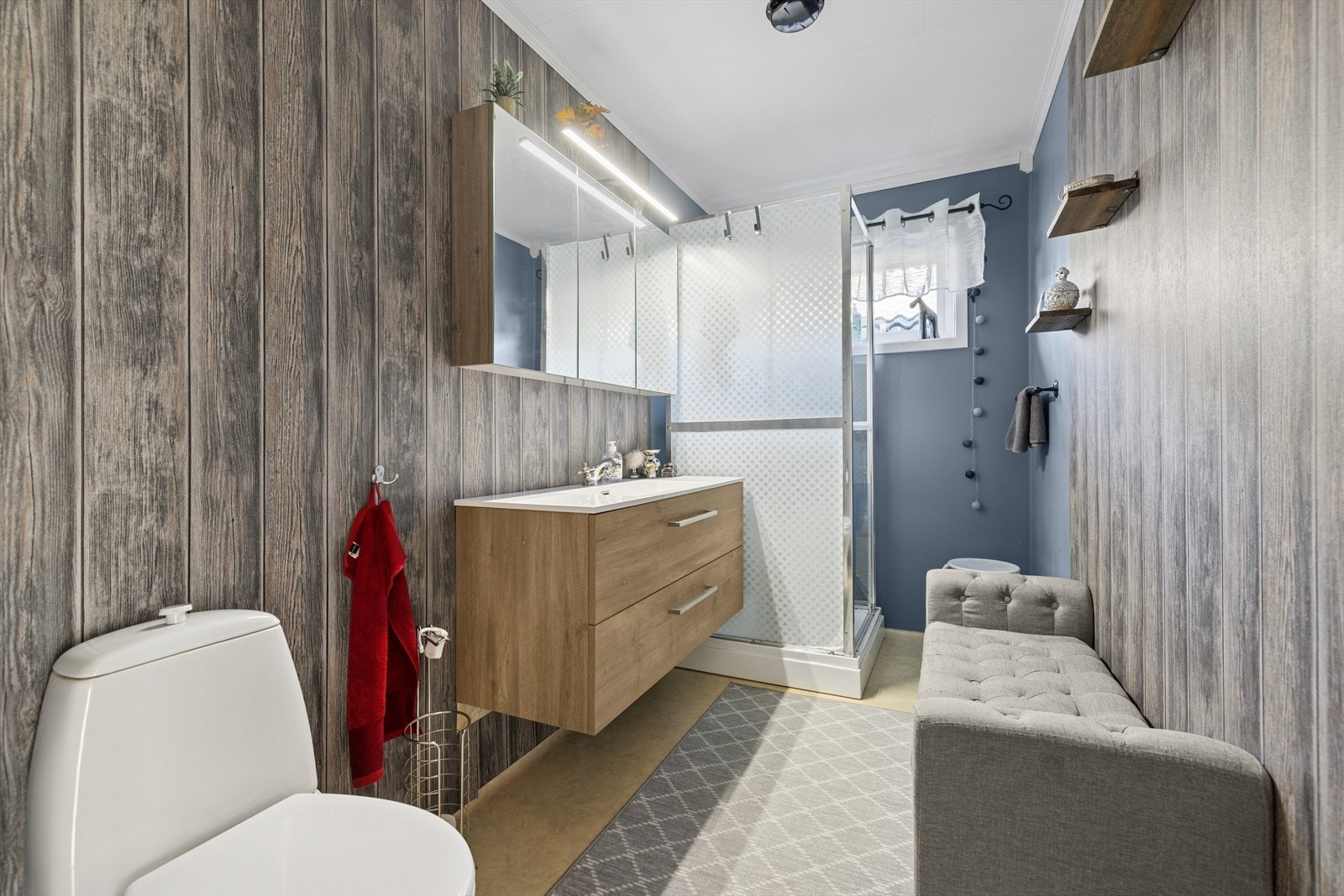 Badet i hovedetasjen ble oppgradert i 2018 med ny innredning, tapet og dusjkabinett. Det har vinylbelegg på gulv, våtromstapet på vegger og himlingsplater i tak. Galleribilde