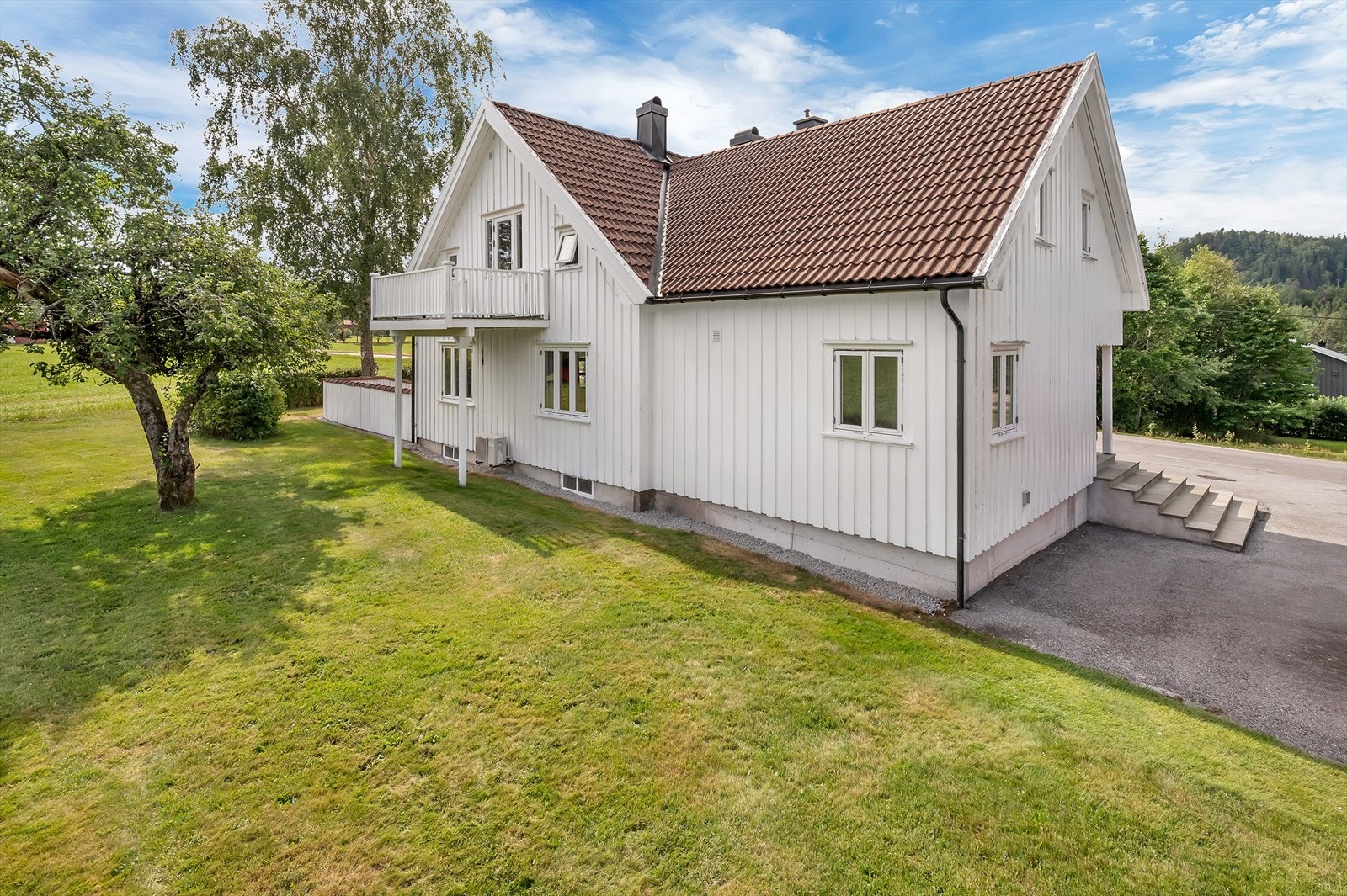 Asfaltert gårdsplass, romslig plen og etablert beplantning Galleribilde