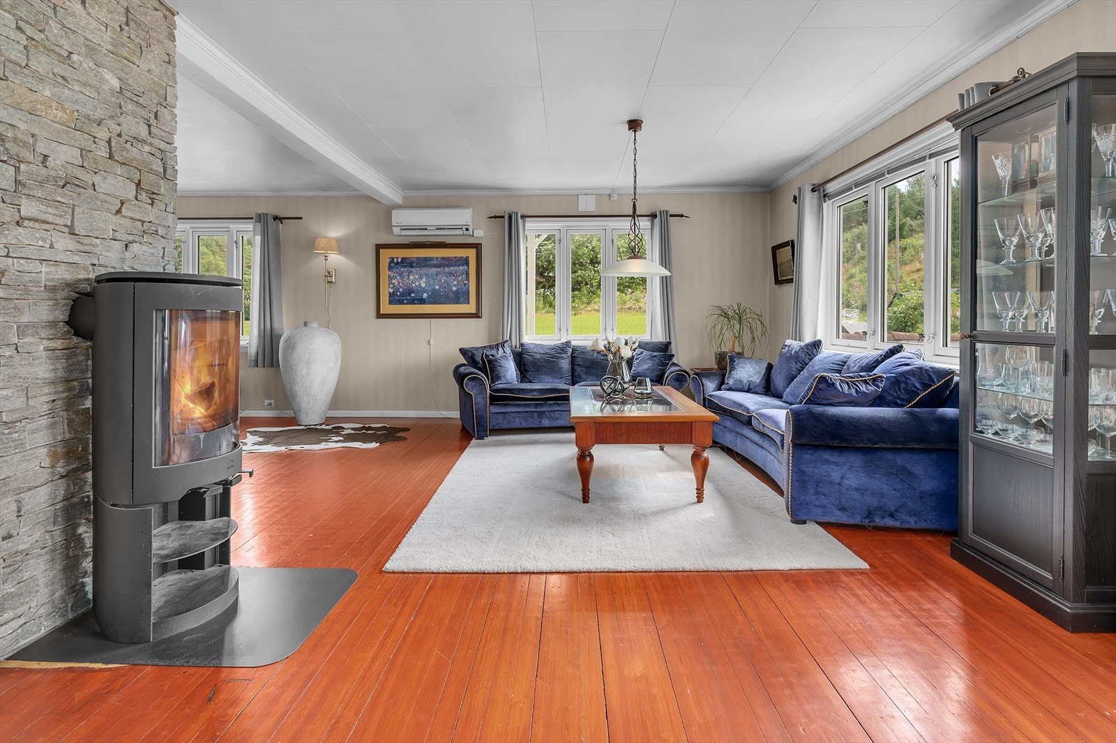 Stor vinkelstue med både varmepumpe og peis Galleribilde