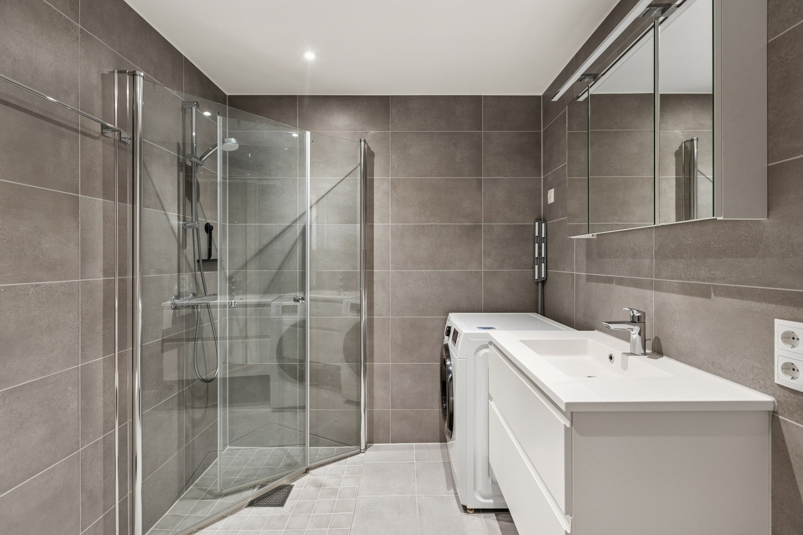 Leiligheten har et pent og flislagt baderom med gulvvarme. Badet har flissatte vegger og malte plater med integrert belysning i himlingen. Galleribilde