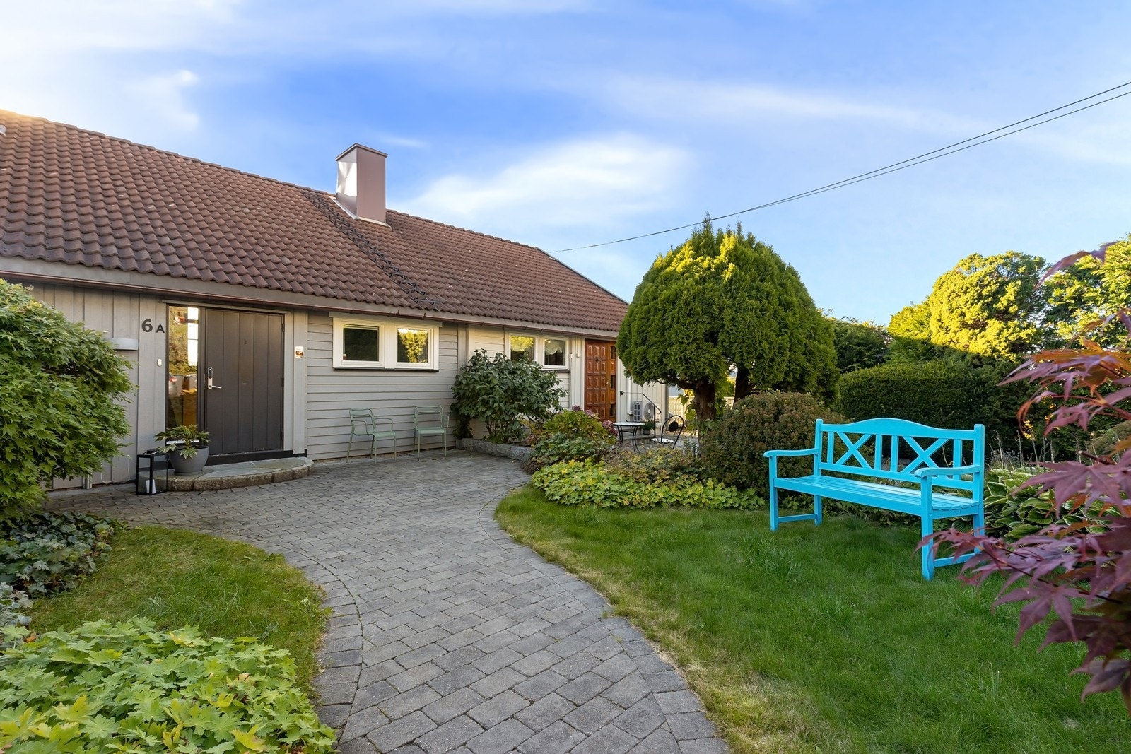 Pent opparbeidet inngangsparti med avsatt plass for sittegruppe og med morgensol Galleribilde