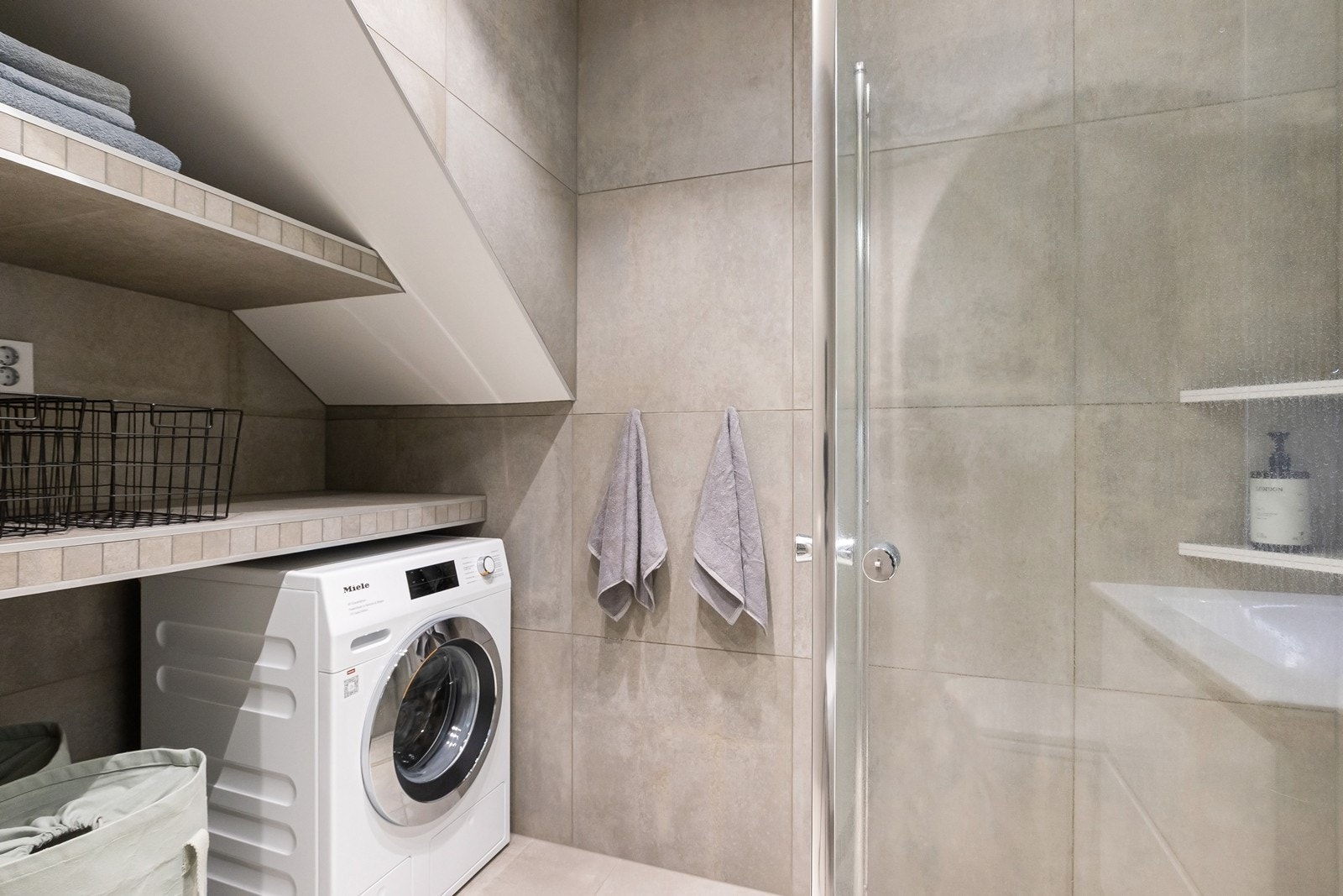 Bad u.etasje med praktisk innredet med plassbygd benk/hylle, og opplegg for vaskemaskin under Galleribilde