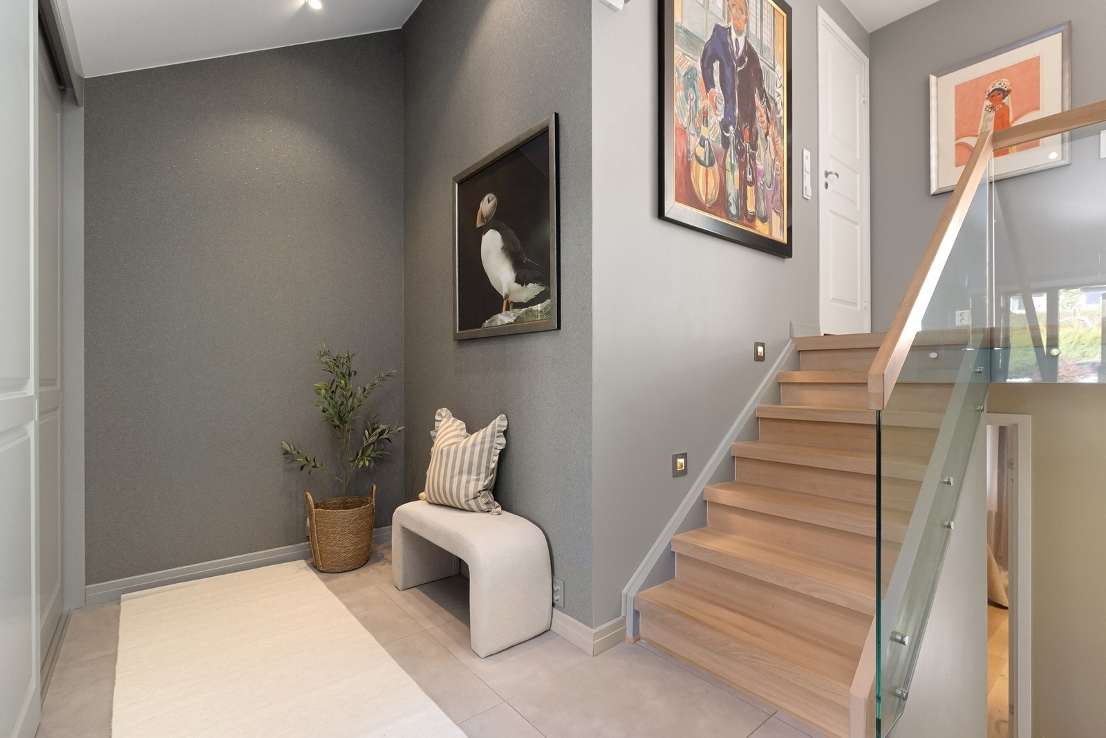 Lekker trapp med veggbelysning og glassrekkverk mellom halvetasjene. Gang/entré med heldekkende garderobeløsning Galleribilde