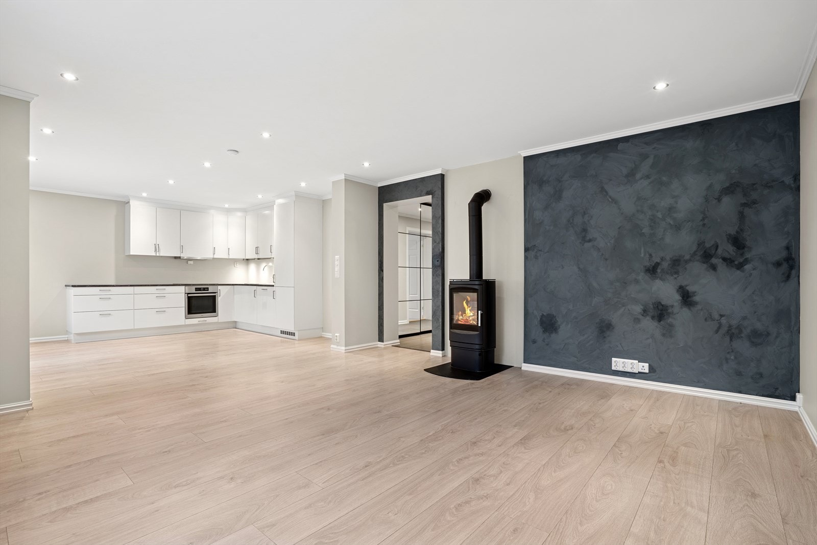 Boligen har en gjennomtenkt og åpen løsning mellom kjøkken og stue, som skaper en luftig og innbydende atmosfære Galleribilde