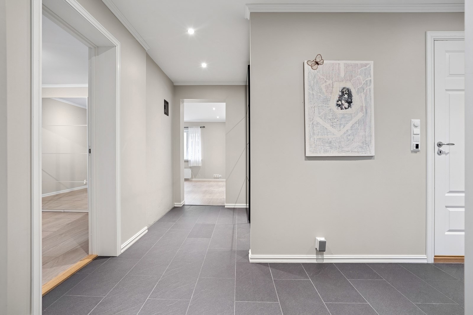 Fra felles trapperom er man velkommen inn i en lys og moderne entré med plass til oppbevaring av yttertøy. Galleribilde