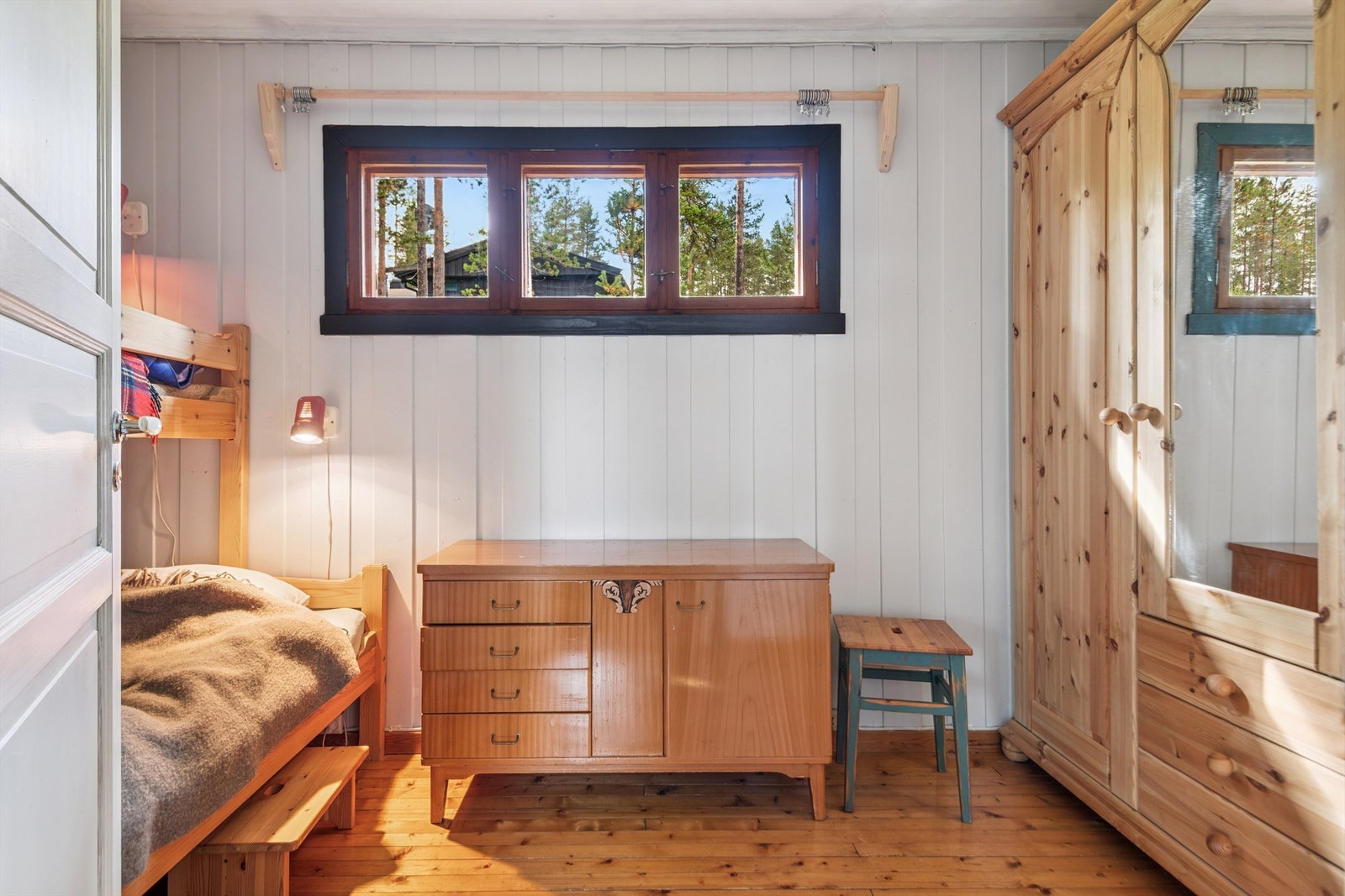 Rommet har plass til oppbevaringsmøbler og har panel på veggene, som er gjennomgående i hytta. Galleribilde