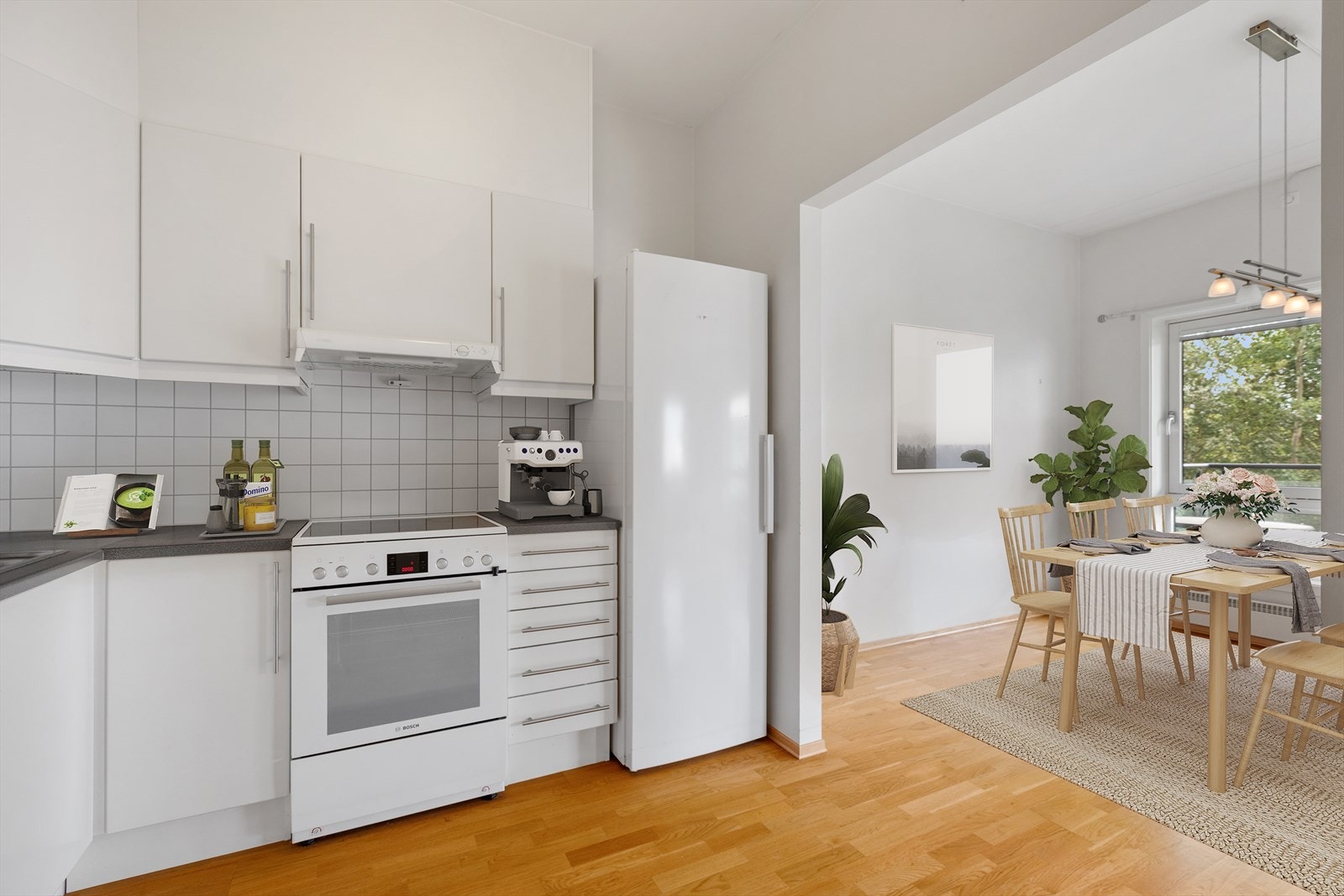 Innredningen består av hvite, slette fronter, laminat benkeplate og flislagt sprutsone. Galleribilde
