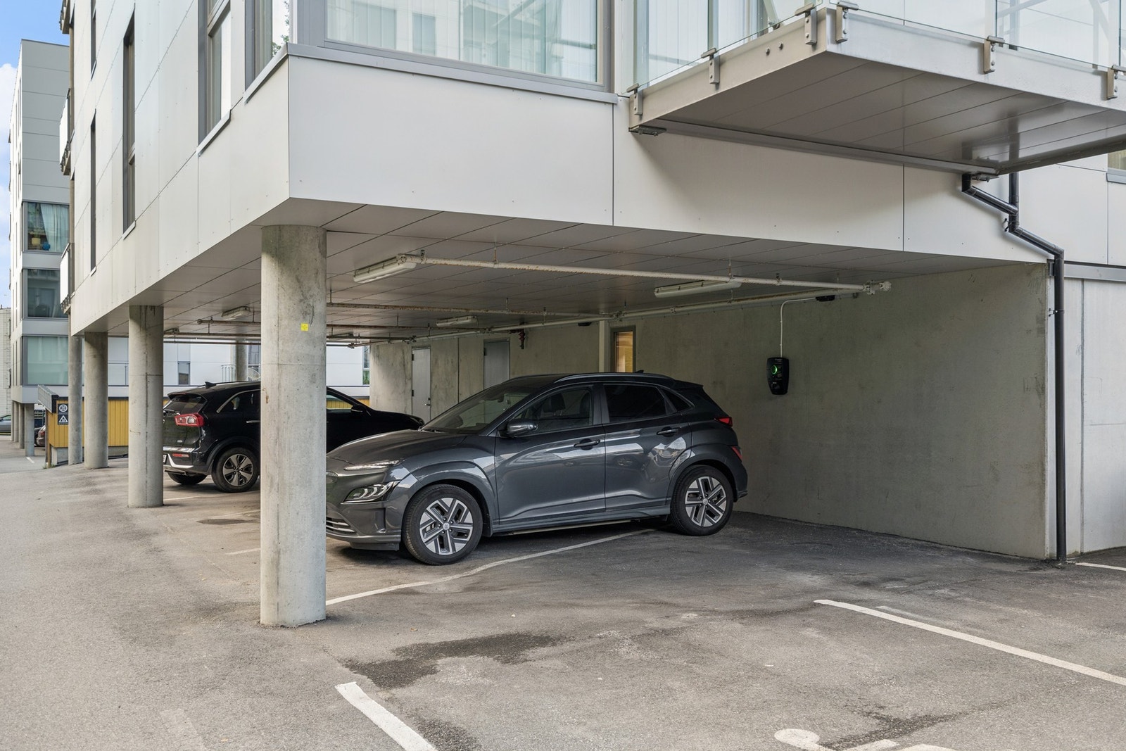 Fast parkering på asfaltert oppstillingsplass med elbillader Galleribilde