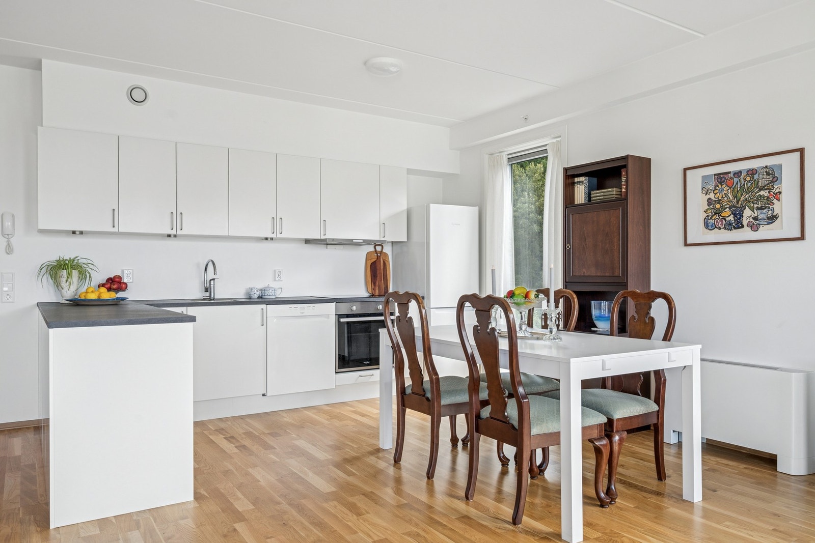 Kjøkkenet er innredet med glatte fronter og benkeplate i laminat Galleribilde