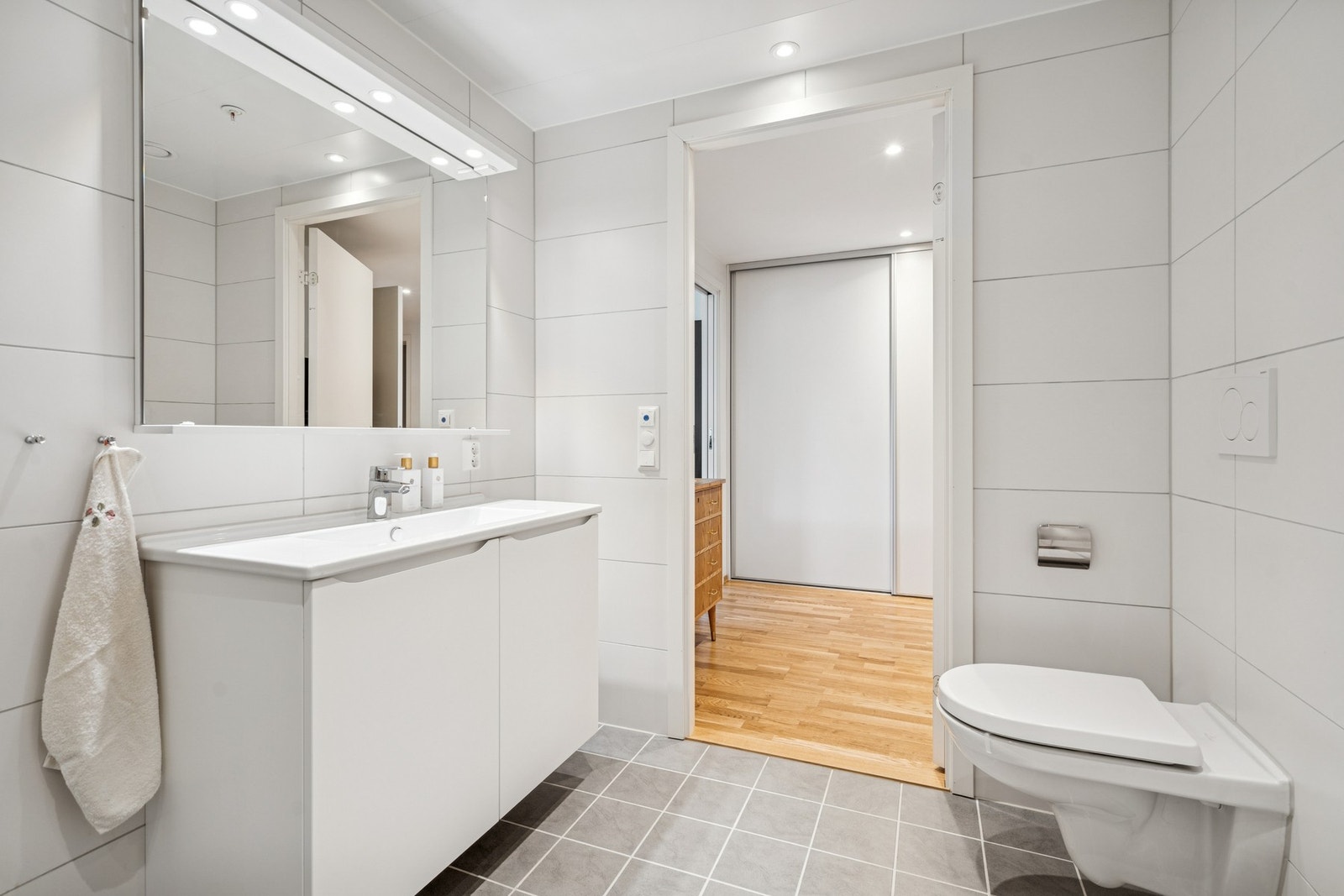 Rommet er innredet med nedfelt servant, veggmontert toalett og dusjvegger/hjørne Galleribilde