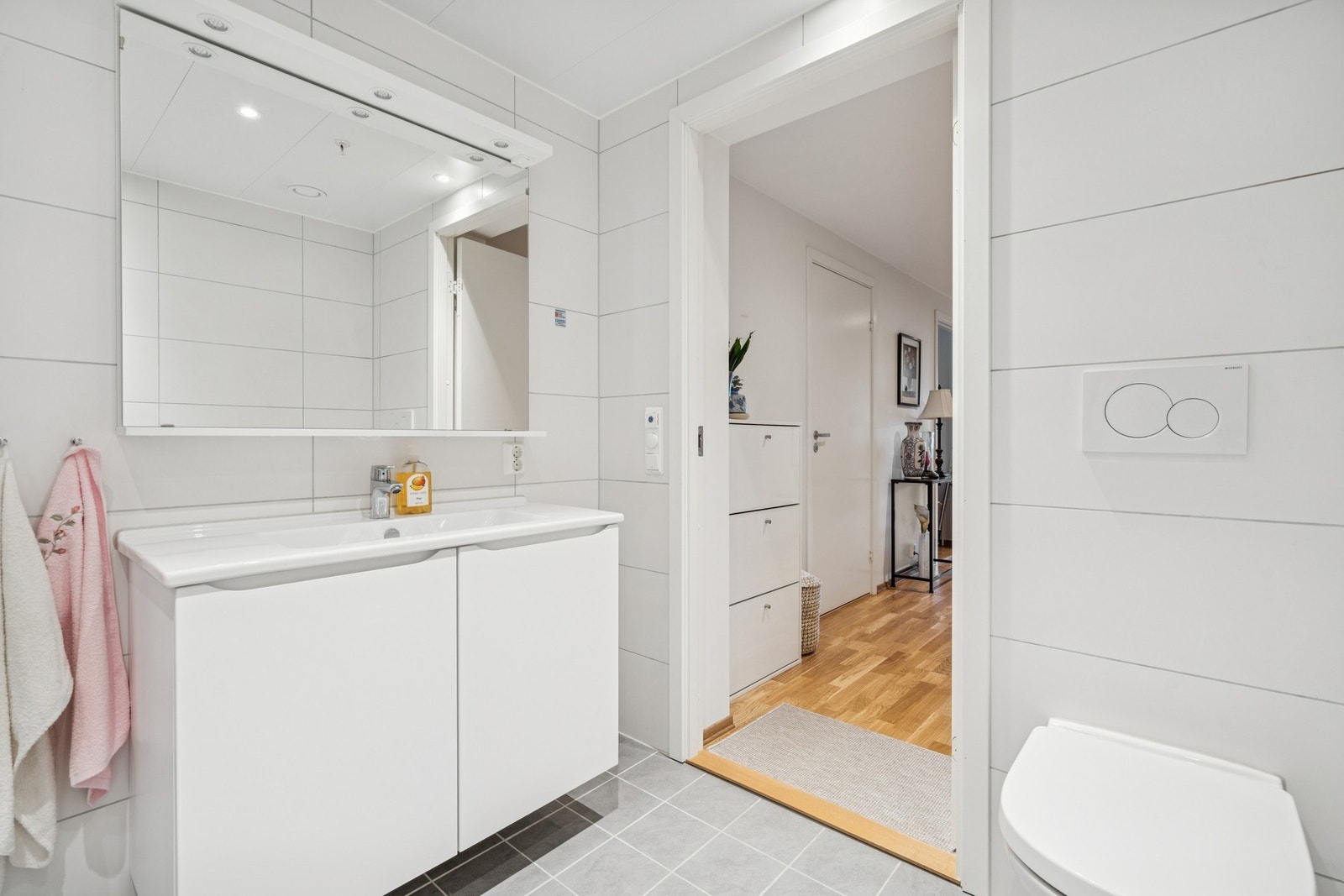 Rommet er innredet med nedfelt servant, veggmontert toalett, dusjvegger/hjørne og opplegg for vaskemaskin Galleribilde