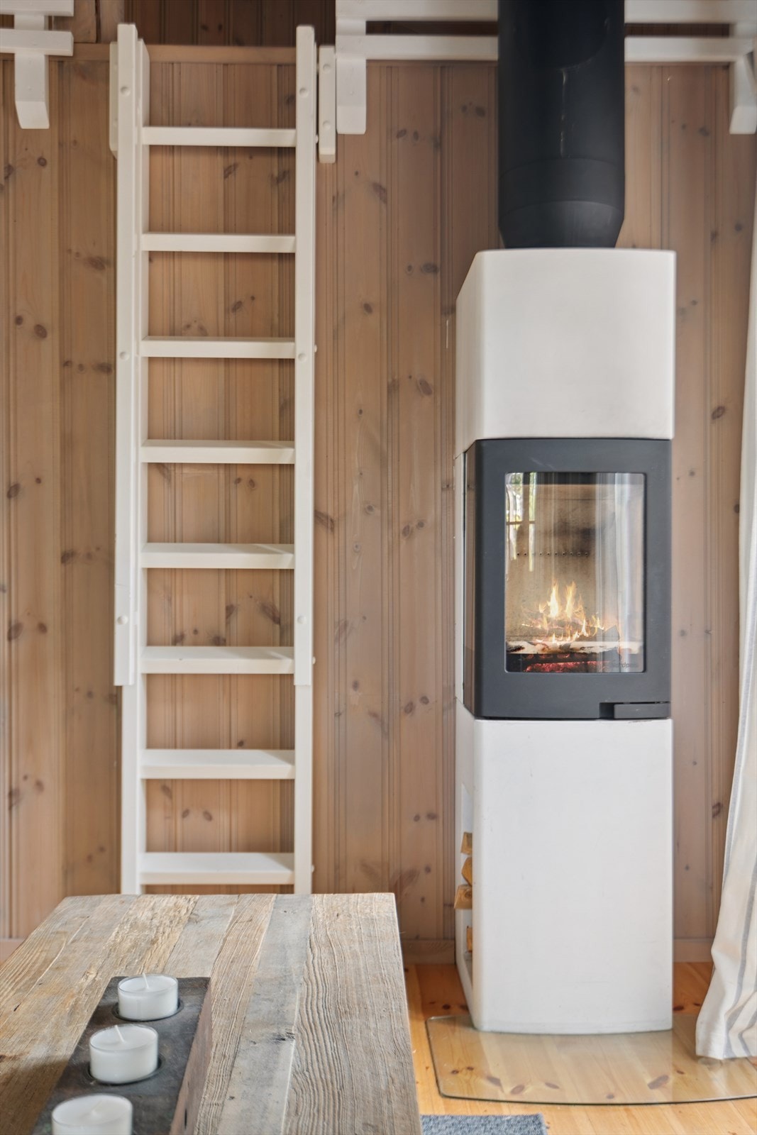 En moderne elementpeis gir varme, og trappestigen leder enkelt opp til hemsen. Galleribilde