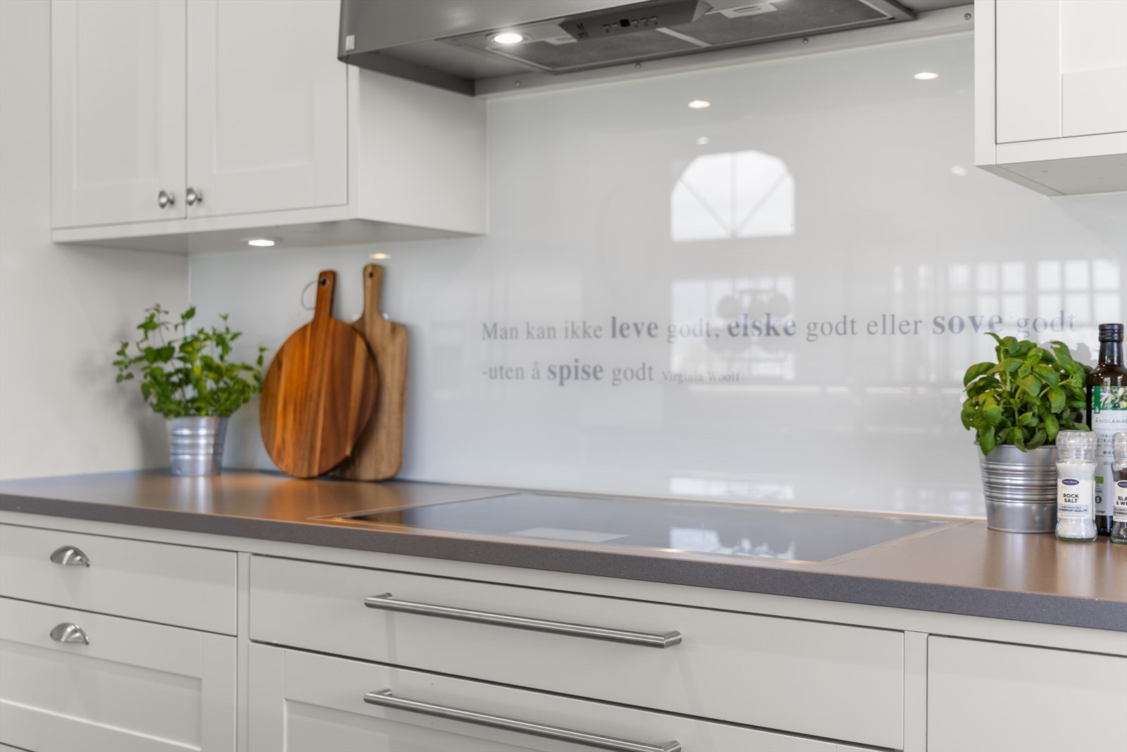 Kjøkkenet har benkeplate av kompositt med glassplate for enkelt renhold Galleribilde