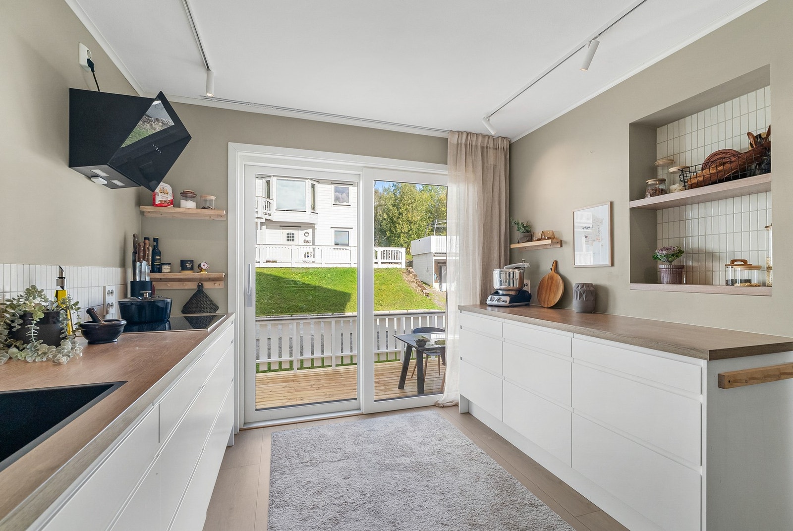 Moderne vegghengt ventilator over integrert platetopp. Godt med benkeplass på kjøkkenet. Galleribilde