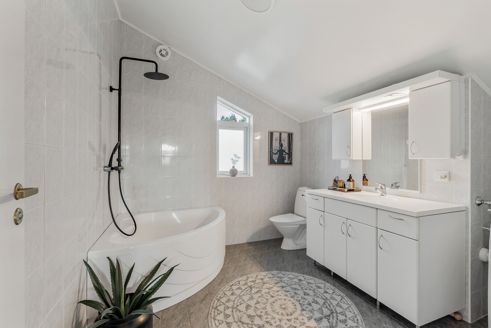 Flislagt bad med varmekabler i gulvet og badekar. Galleribilde