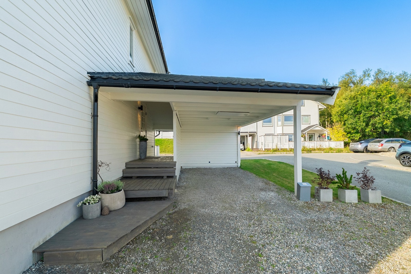 Romslig carport med hems og sportsbod. Takoverbygd inngangsparti. Galleribilde