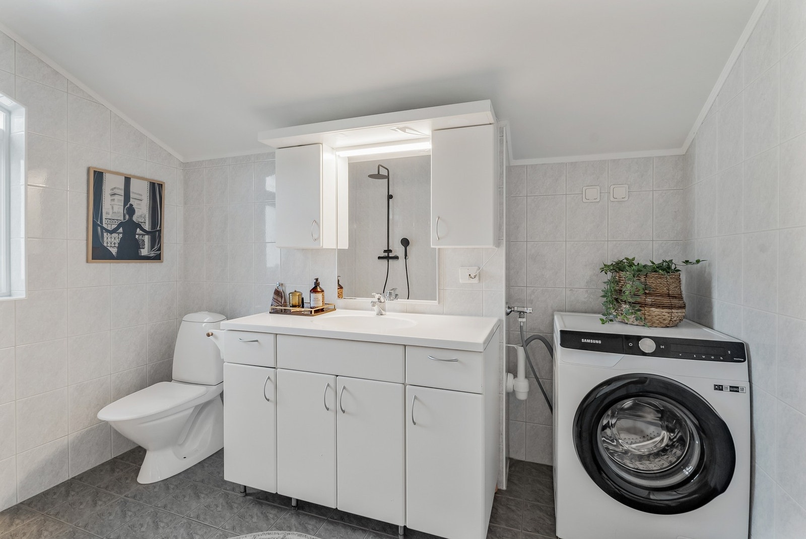 Rommet har stilren innredning og opplegg for vaskemaskin. Galleribilde