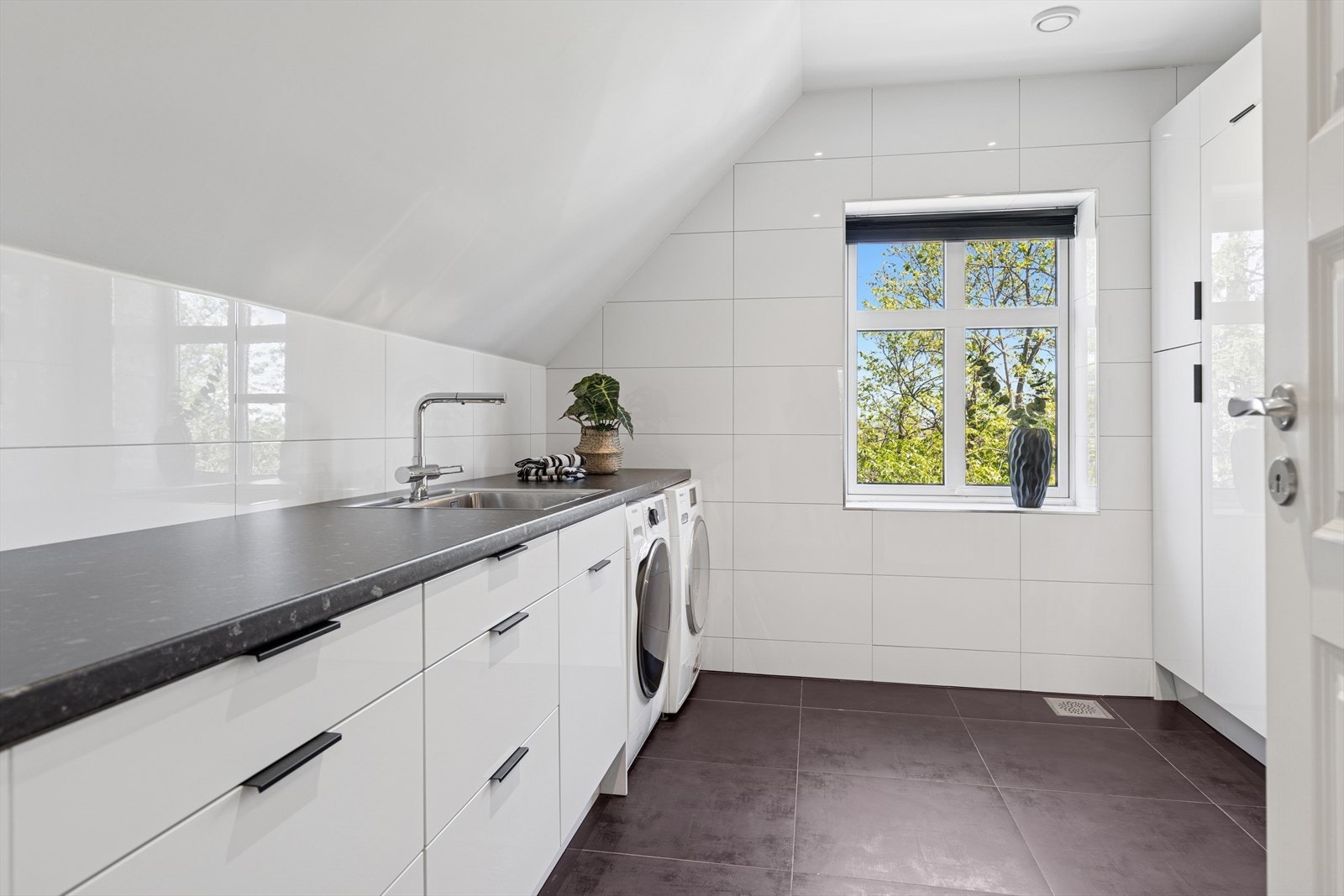 Funksjonelt vaskerom med god lagringsplass og opplegg til vaskemaskin og tørketrommel. Galleribilde