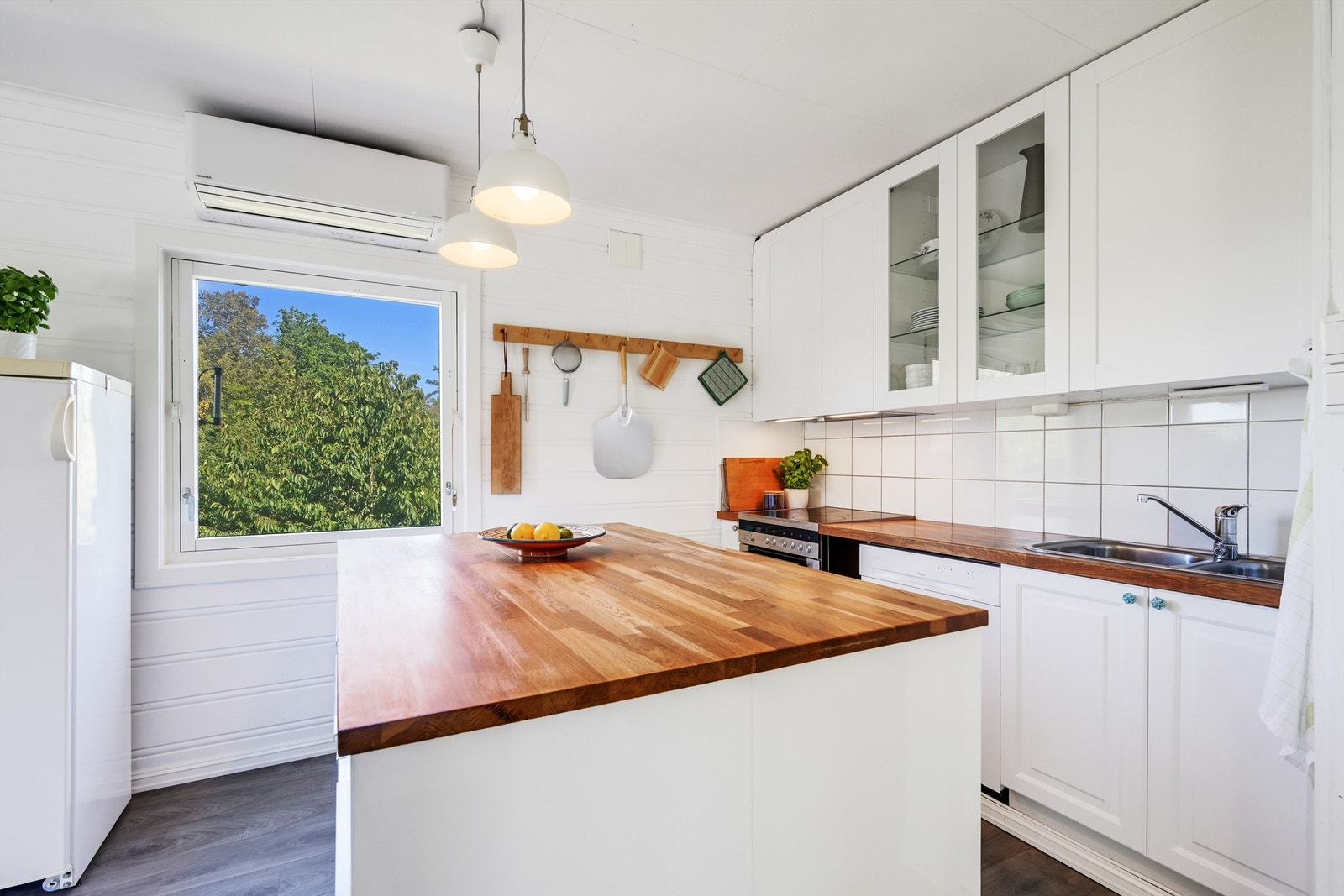 Koselig og stemningsfullt kjøkken med profilerte fronter og en benkeplate i heltre Galleribilde