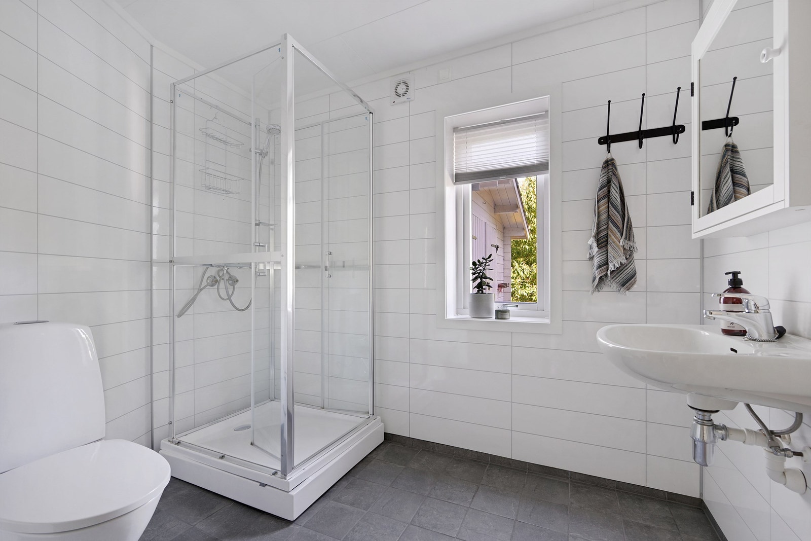 Badet er innredet med servant, toalett og dusjkabinett Galleribilde