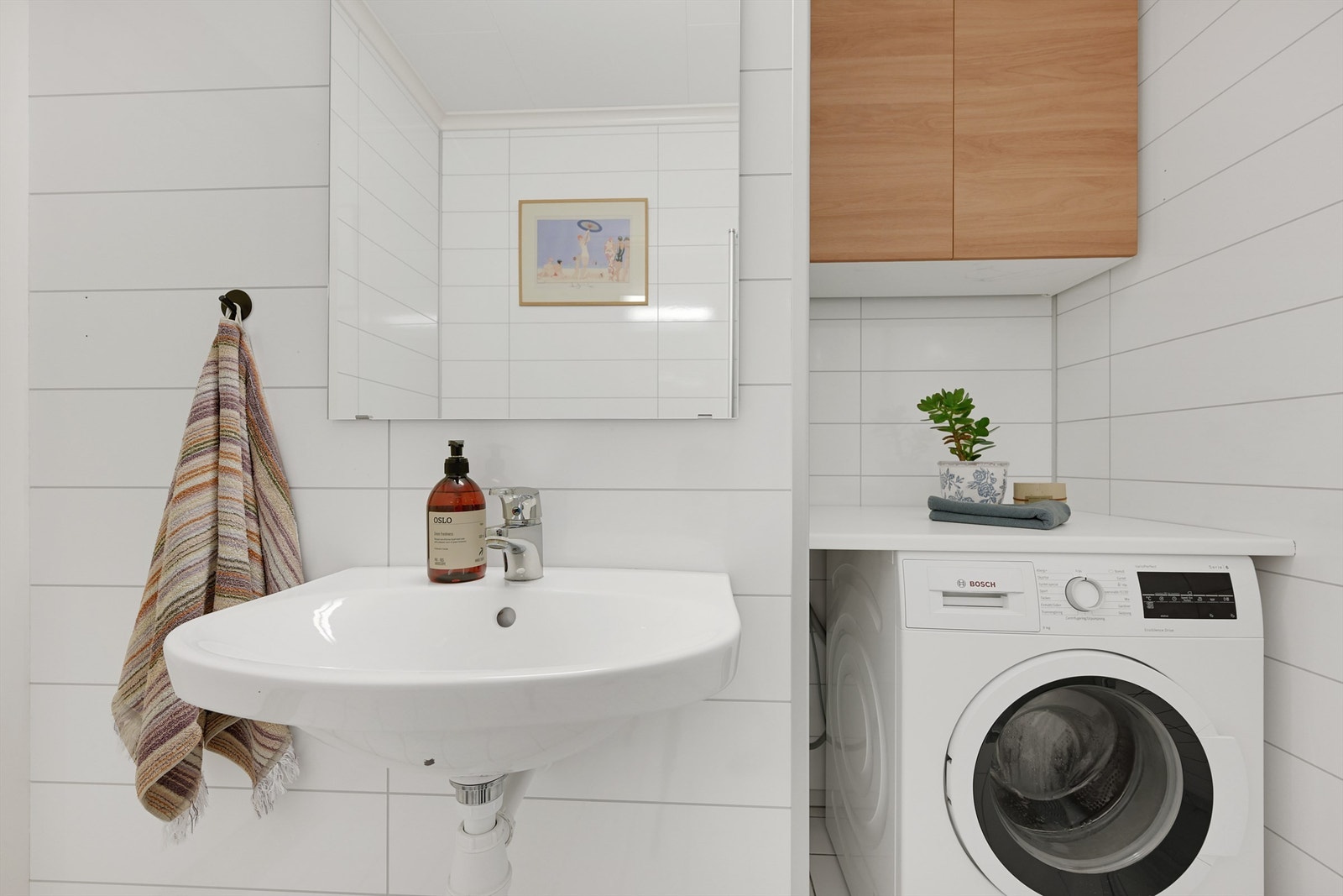 Badet har servant, toalett, dusj og opplegg for vaskemaskin Galleribilde