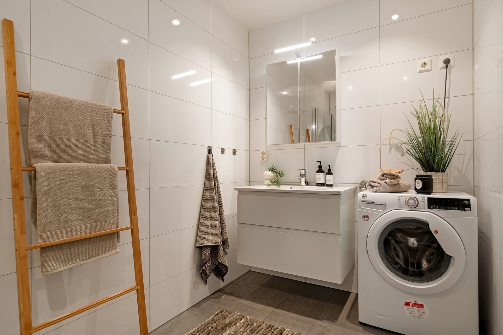 Badet har opplegg for vaskemaskin, moderne innredning og varmekabler i gulvet. Galleribilde