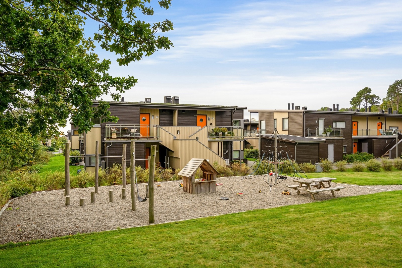 Pent opparbeidet fellesområde med lekeplass, plenarealer og beplantning Galleribilde