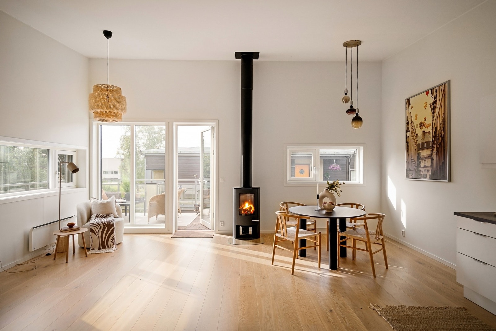 Store vindusflater og peisovn gir stuen både lys, varme og en lun atmosfære Galleribilde