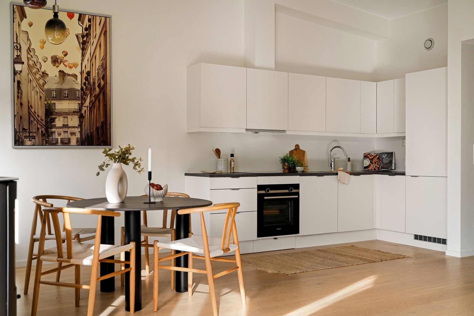 HTH-kjøkken med hvite, glatte fronter og mørk laminert benkeplate Galleribilde